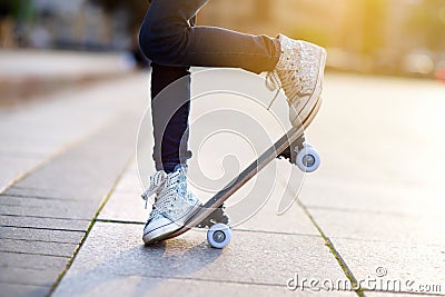 Closeup of skateboarder legs. Kid riding skateboard outdoor. Stock Photo