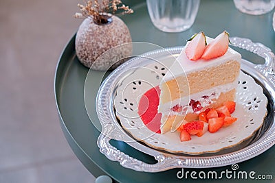 A slice of sponge cake on the plate, Strawberry shortcake with sliced strawberries on wooden table Stock Photo