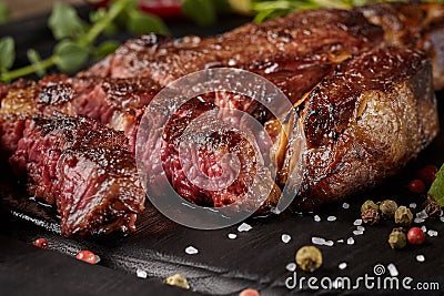 Closeup of sliced beef entrecote with condiments and greens Stock Photo