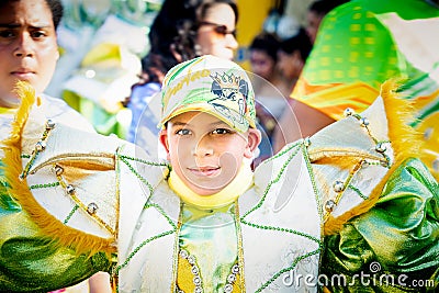 Closeup small boy in pied costume looks at camera on dominican annual carnival Editorial Stock Photo