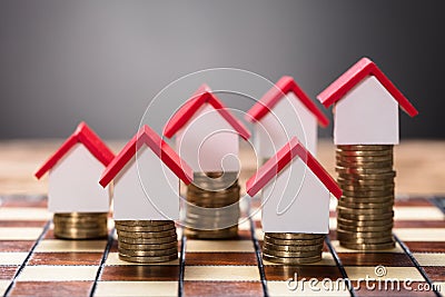 Small Houses On Stacked Coins Stock Photo