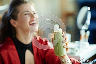 Woman with bottle of yoghurt in house in sunny day Stock Photo