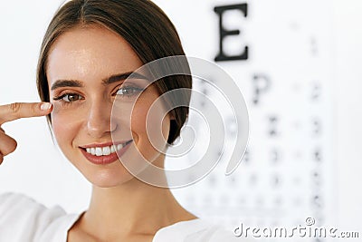 Closeup Of Smiling Young Woman In Front Of Visual Eye Test Board Stock Photo