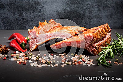 Closeup smoked ribs with spices, rosemary and two chili peppers Stock Photo