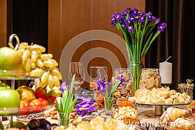 Closeup snacks, fresh and dried fruits, pieces parmesan cheese, honeycombs, dark chocolate, cinnamon sticks, nuts, biscotti. Stock Photo