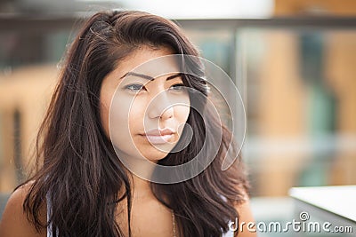 Closeup of a Serious young Spanish woman looking at the camera. She is sad outside. Stock Photo