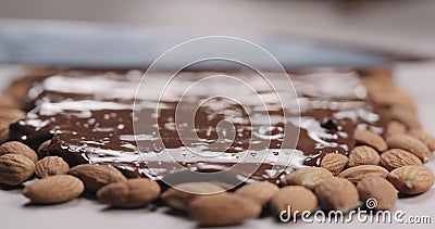 Closeup spreading chocolate over roasted almonds Stock Photo