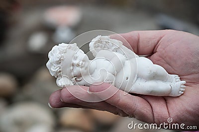 Stoned angel in hand of woman in cemetery Stock Photo