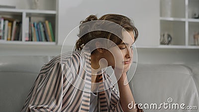 Closeup student studying home alone. Tired girl making notes on cozy couch. Stock Photo