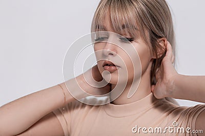 Closeup studio portrait of a female face with clean healthy skin with sexy lips. Attractive young blonde woman straightens hair Stock Photo