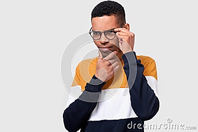 Closeup studio portrait of young African American man wearing and looking through round trendy spectacles. Serious businessman Stock Photo