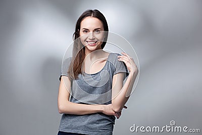 Closeup studio portrait of young woman in grey shirt Stock Photo