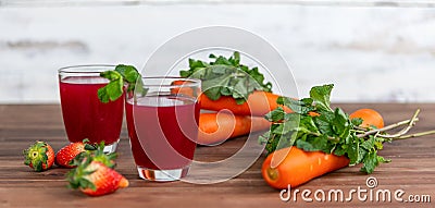 Closeup studio shot two glasses of freshly blended squeezed decorated with strawberry and carrot healthy diet vegan drink fresh Stock Photo