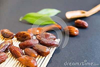 Closeup sweet dried date palm fruits or kurma, ramadan ramazan food. Natural light. Selective focus. Close up on a black backgro Stock Photo