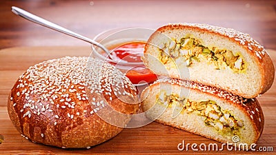 Closeup of tasty brioche chicken curry buns and tomato sauce on a wooden board Stock Photo