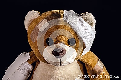 Closeup of teddy bear bandaged with bandages and band aid, concept of child abuse or violence, image representing domestic Stock Photo