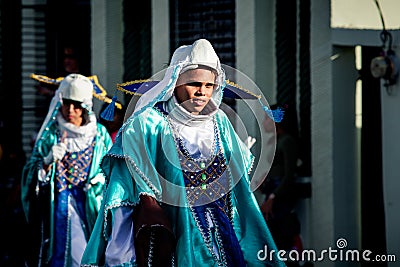 Closeup teenagers in brilliant blue costumes walk by city street at dominican carnival Editorial Stock Photo