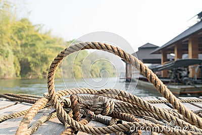 Closeup thick rope tie on the wooden terrace near river Stock Photo