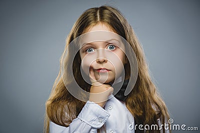 Closeup Thoughtful Young girl Looking Up with Hand at Face isolated on Gray Background Stock Photo