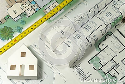 Closeup to floor plans, white paper house, measuring yellow tape. Architect drawings, expensive renovation, building construction Stock Photo