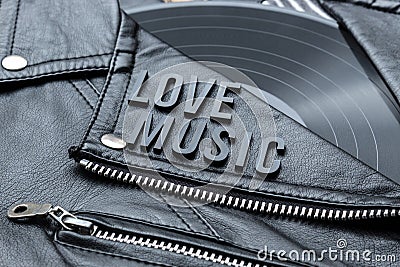 Closeup to a love music lettering art over a black leather biker jacket with LP vinyl disc Stock Photo