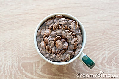 Closeup top view of many coffee beans in the ceramic mug with copy space for adding some text Stock Photo