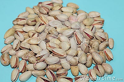Closeup top view of pistachios in shells gathered on a blue background in a studio Stock Photo