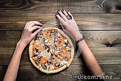 CLOSEUP Top view VERY HOT SLICED Italian Pizza with hand take a slice on wooden table with mushrooms, tomato, olives and Stock Photo