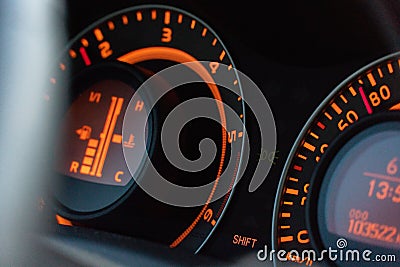 Closeup of the Toyota Auris fuel consumption sign in a car with orange lights Stock Photo