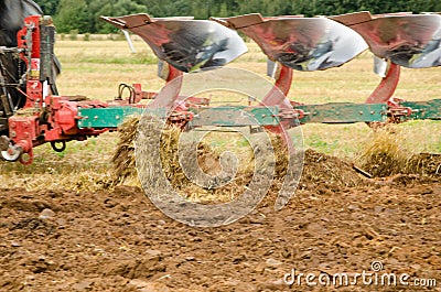 Closeup tractor plough plowing agricultural field Stock Photo