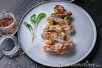 Closeup turkey steak with cherry tomatoes, arugula and spices on a round plate on a dark background Stock Photo