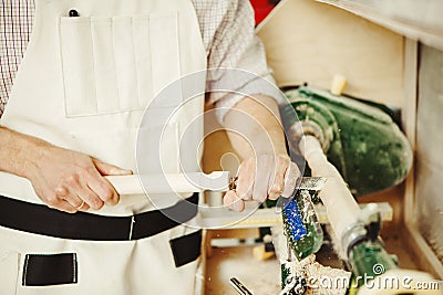 Closeup turner engages in wood carving on lathe for wood Stock Photo