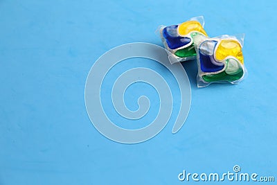 Closeup of two dishwasher capsules on a blue background Stock Photo