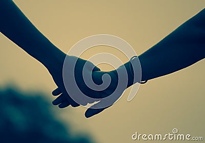 Closeup of two persons friends couples holding hands in the sky Stock Photo