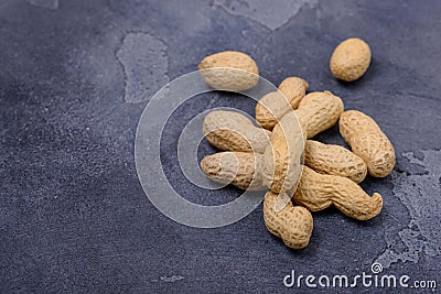 Closeup unpeeled peanuts on stone background Stock Photo