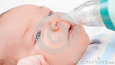 Closeup of using nasal aspirator for cleaning newborn baby nose from mucus. Concept of babies and newborn hygiene and Stock Photo