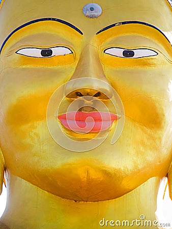 Closeup vibrant gold Shanti Ban Buddha face, golden Buddha`s image in Dhulikhel, Nepal Stock Photo