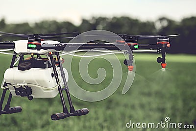 Closeup view of agriculture drone spraying water fertilizer on the green field Stock Photo