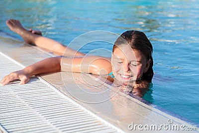 Closeup view of beautiful gorgeous pretty little girl relaxing and swimming in pool with natural ocean water Stock Photo