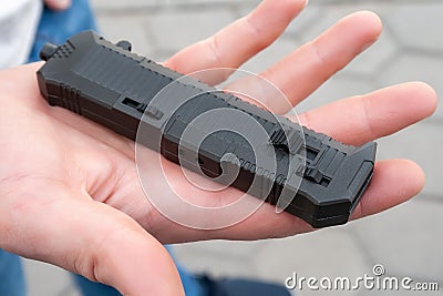 Closeup view of a black pocket folding knife lying on the palm Stock Photo