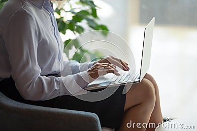 Closeup view businesswoman put computer on lap typing e-mail Stock Photo