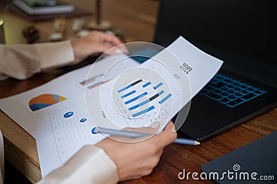 Closeup view of businesswoman reviewing sales plan with graphic statistics for 2022 Stock Photo