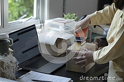 Closeup view of female online store small business owner seller entrepreneur packing package post shipping box preparing delivery Stock Photo