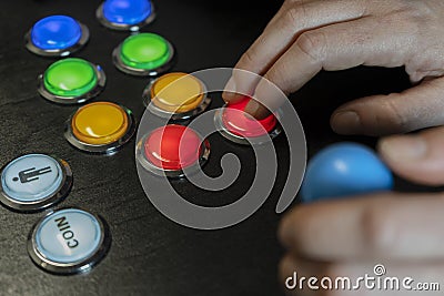 Closeup view of hands playing arcade old video games.Gamepad with joystick and many colorful buttons .Gaming with old retro Stock Photo