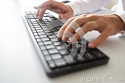 Closeup view of male hands using black computer keyboard Stock Photo
