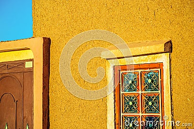 Rammed earth wall with traditional wrought iron window Stock Photo