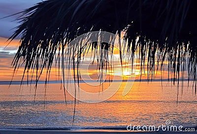 Closeup view of straw umbrella at sunset,paradise tropical beach,no people,amazing sea view,holiday,ocean background,bright sky Stock Photo