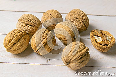 Closeup of walnuts scattered on a white wooden table Stock Photo