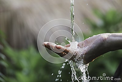 Closeup water flow to hand of women for nature concept on the garden background Stock Photo