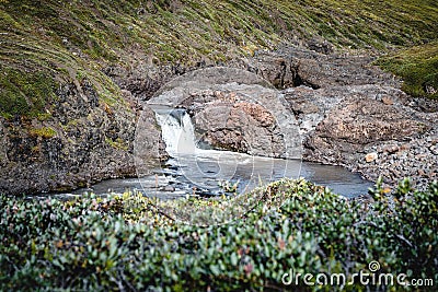 Closeup of a waterfall in a rocky environment on Island of kuannit, Disko Island in Greenland. Stock Photo